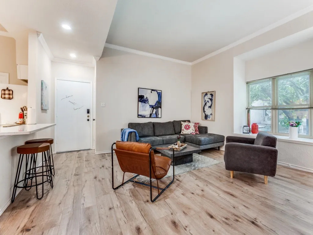 Living area featuring ornamental molding, light wood-style floors, and recessed lighting