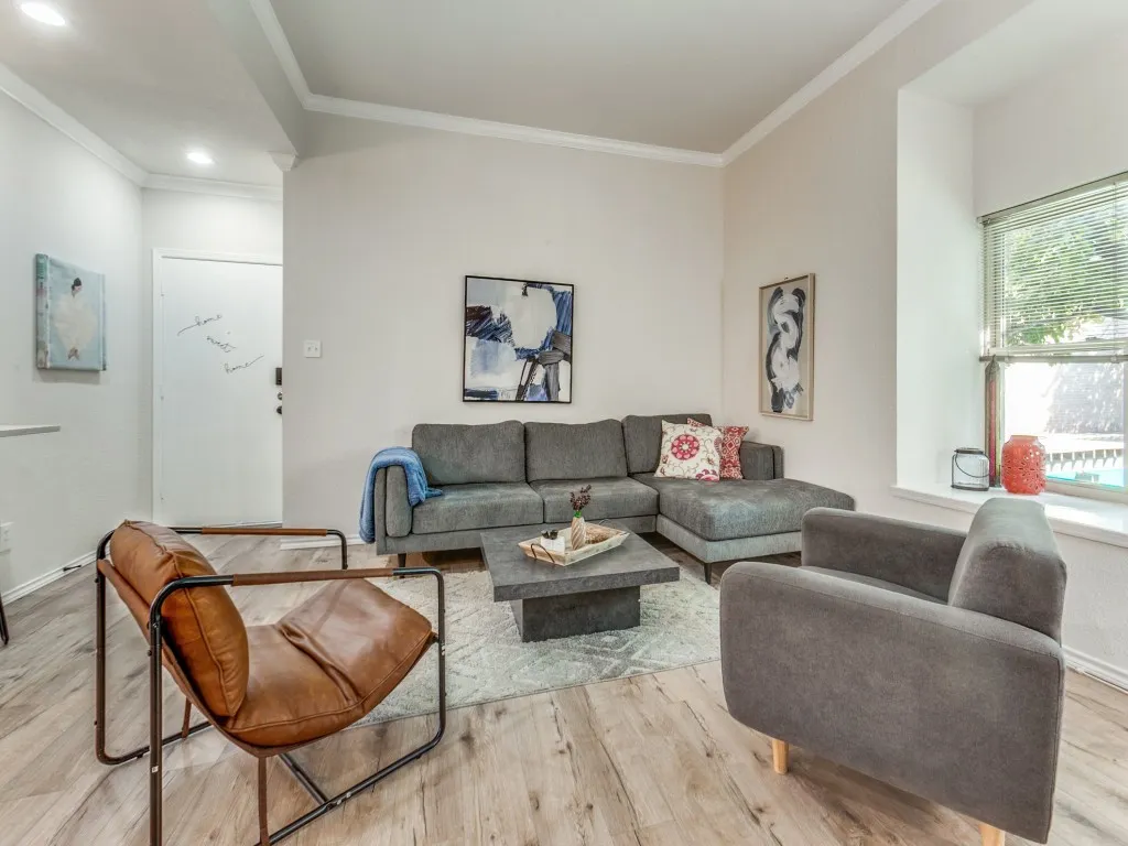 Living area with crown molding and light wood finished floors