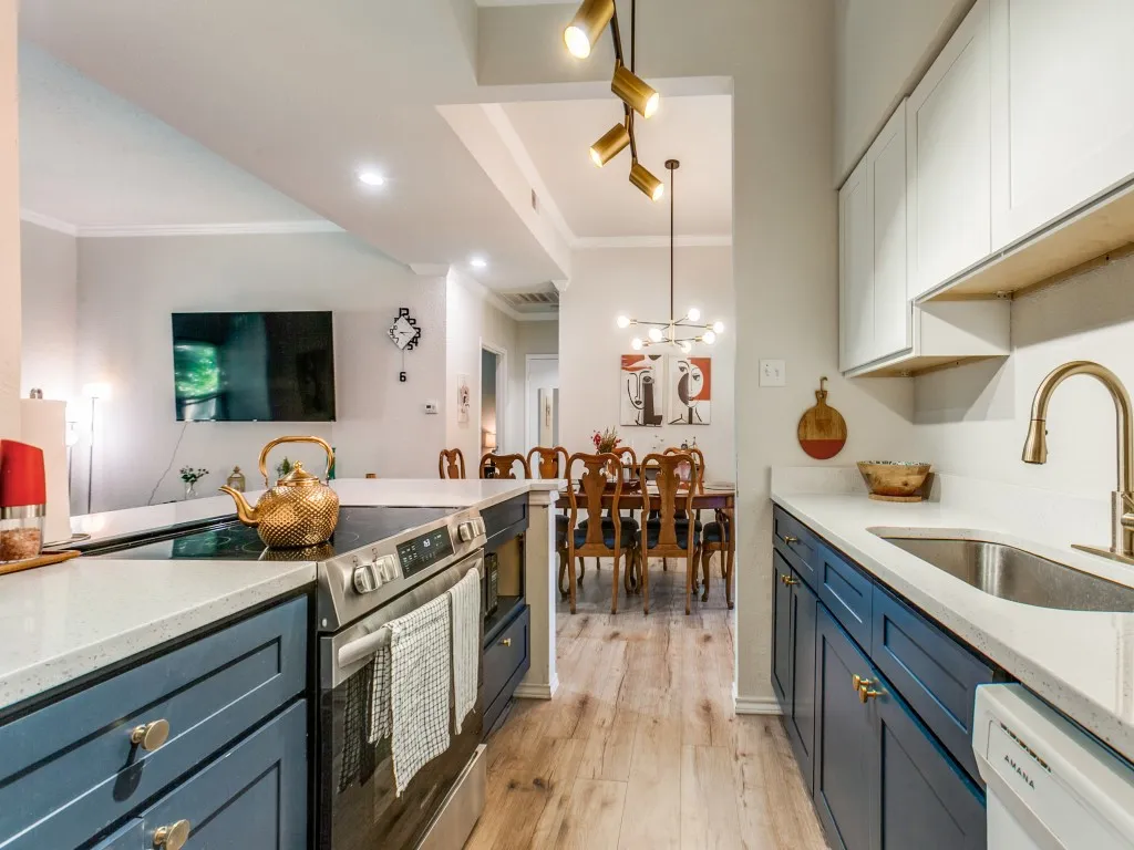 Kitchen with ornamental molding, light stone counters, electric range, light wood-style flooring, and dishwasher