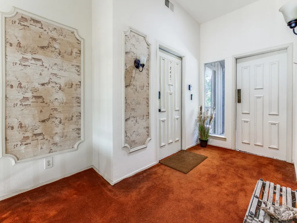 Carpeted entrance foyer with baseboards