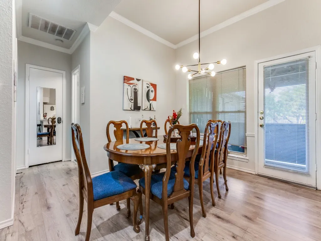 Dining space featuring crown molding, light wood-style floors, and a chandelier