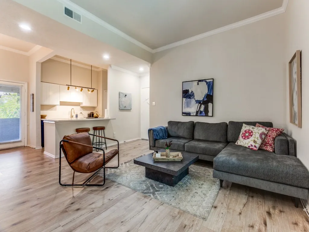 Living area featuring ornamental molding, light wood-type flooring, and recessed lighting