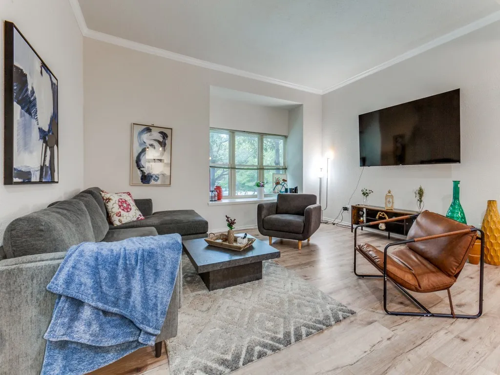 Living room with ornamental molding and wood finished floors