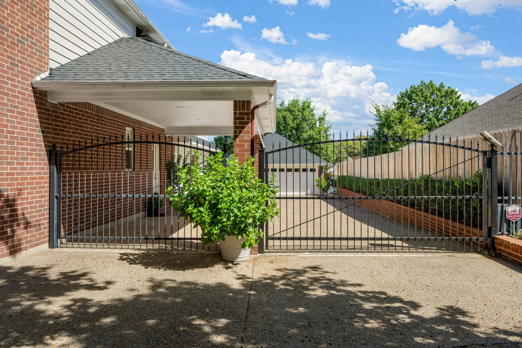 Two electronic gates enclose the parking area.