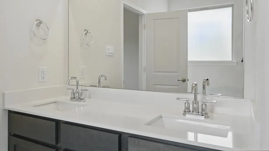 Dual vanity featuring a white countertop, undermount sinks, chrome faucets, and dark cabinetry