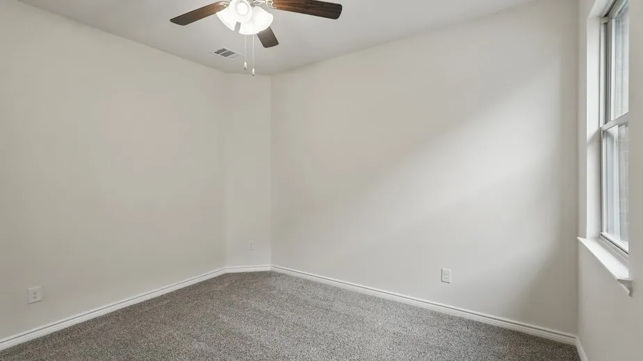 Room featuring light-toned walls, gray carpet, and white trim