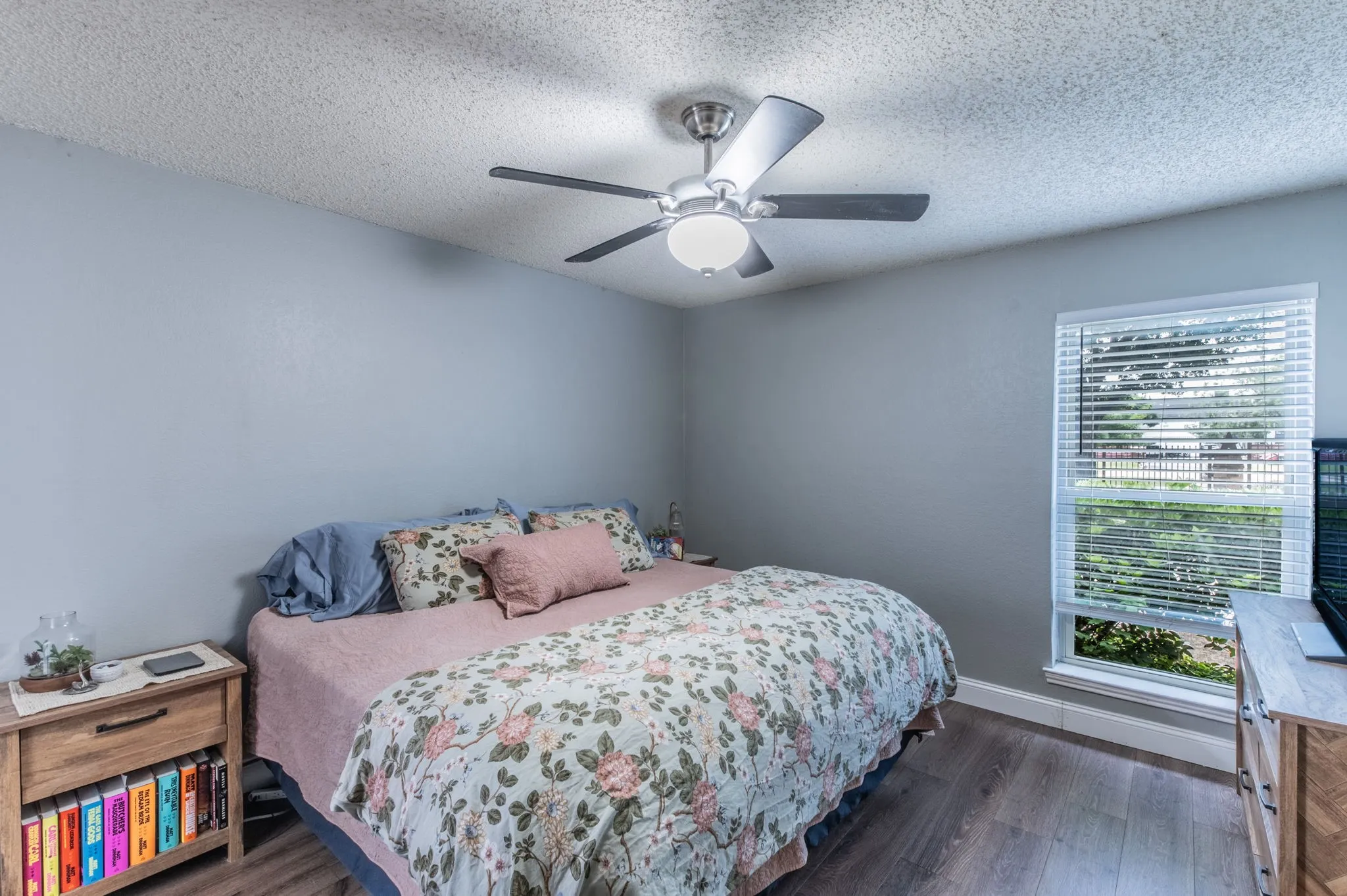 Spacious primary bedroom with neutral colors and luxury vinyl plank floors.