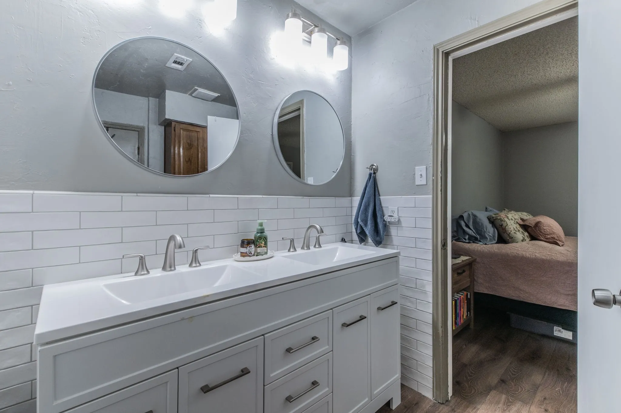 UPDATED Bathroom with tile wall and dual sinks.
