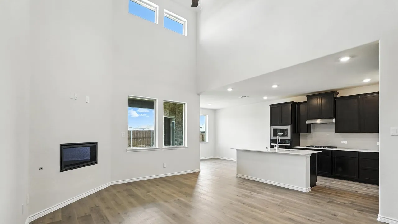 Two-story living area with an integrated fireplace and wood-finish flooring