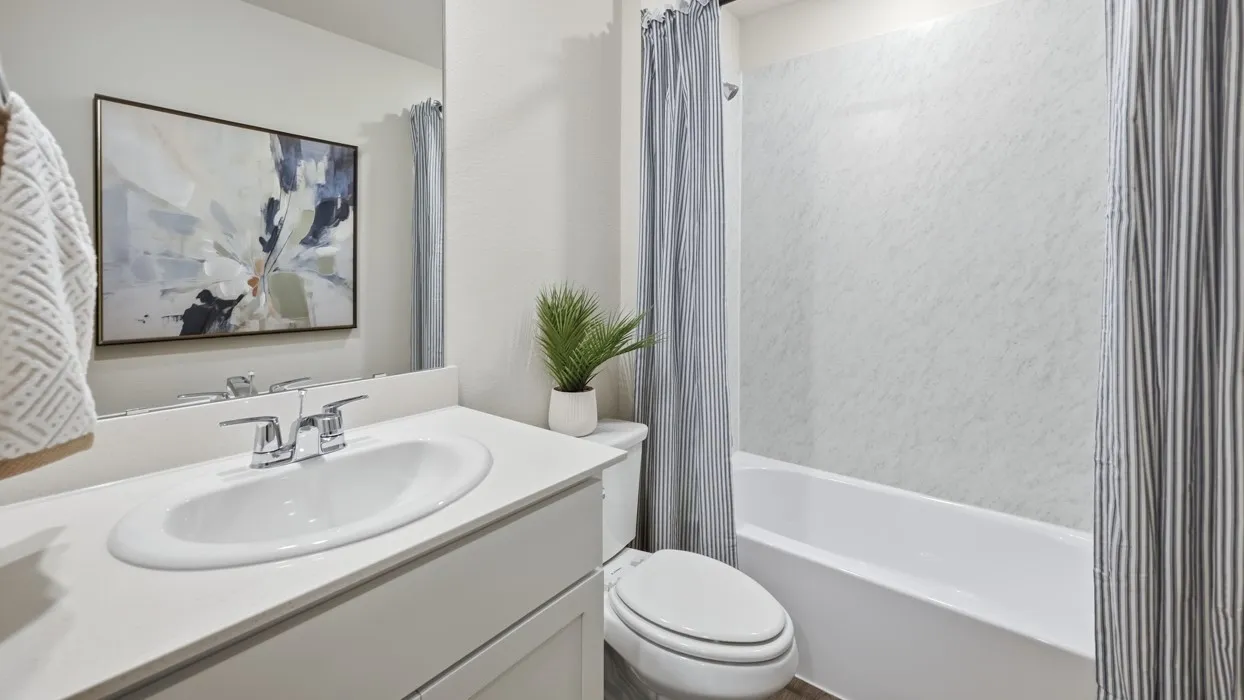 Bathroom featuring a white vanity with an integrated sink, chrome faucet, and a large wall-mounted mirror