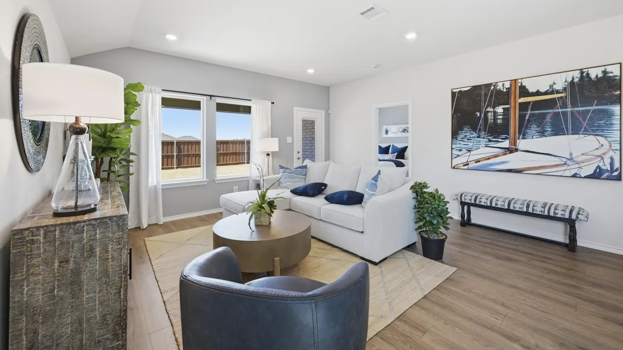 Spacious living area featuring wood-finish flooring, vaulted ceilings, and recessed lighting