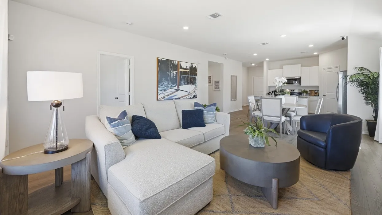 Open-concept living area featuring light wood-finish flooring, recessed lighting, and a neutral color palette