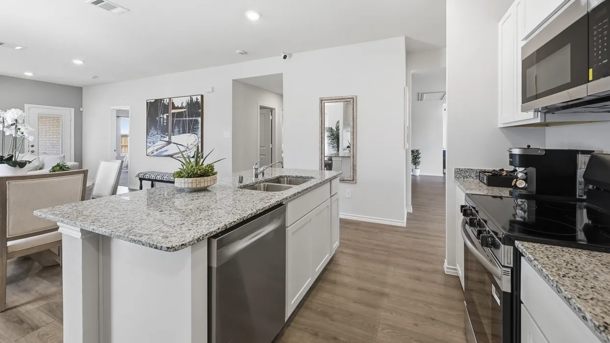 Kitchen featuring a central island with a double basin sink and stainless steel dishwasher