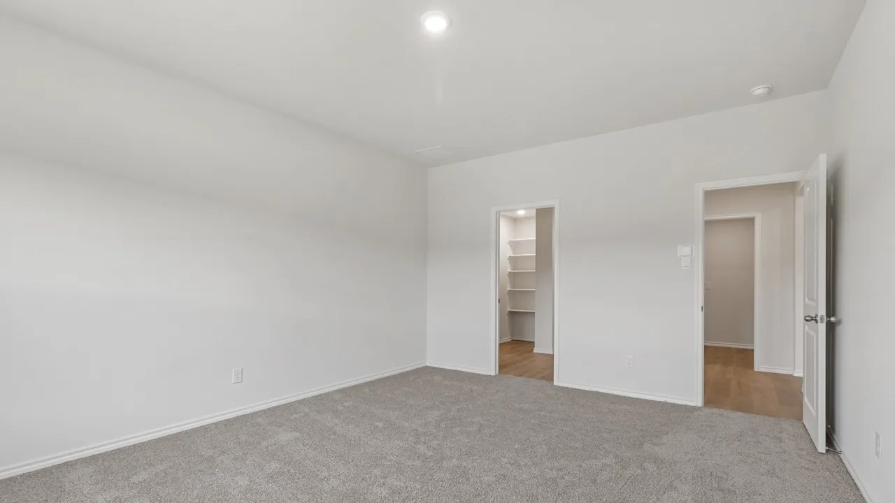 Spacious room featuring light gray carpet, white walls, and a recessed ceiling light