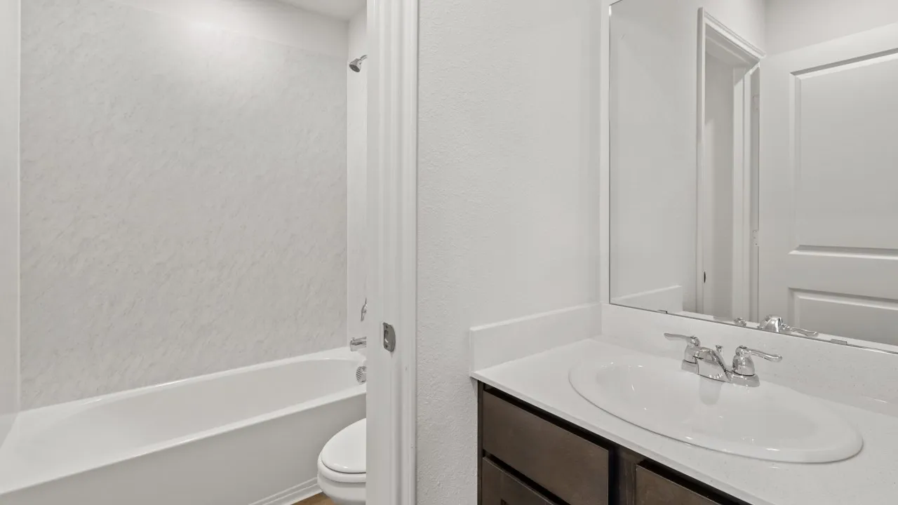 Bathroom vanity featuring a white countertop with an integrated sink, polished chrome faucet, and a wall-mounted mirror