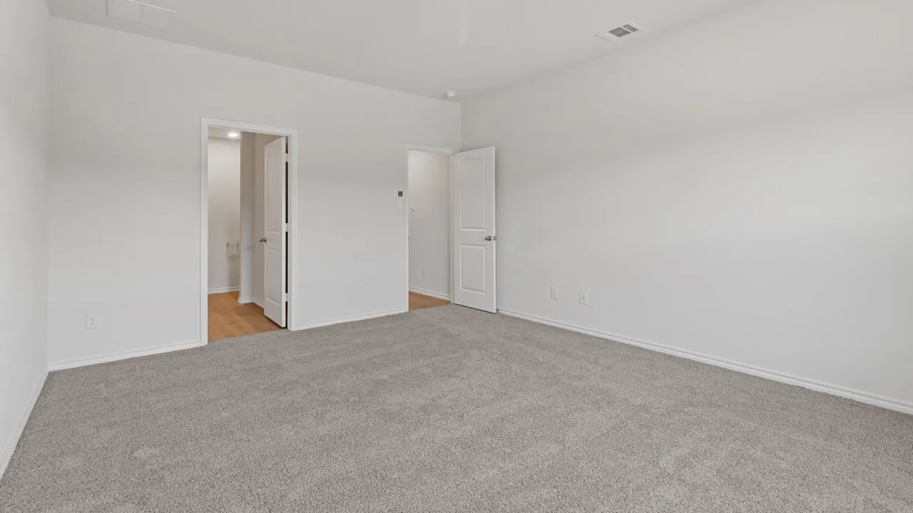 Spacious room featuring light gray carpeting and white painted walls