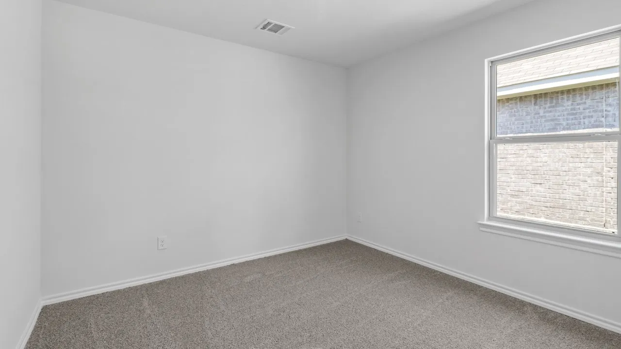 Neutral-toned room featuring a window with white trim, gray carpet, and white baseboards