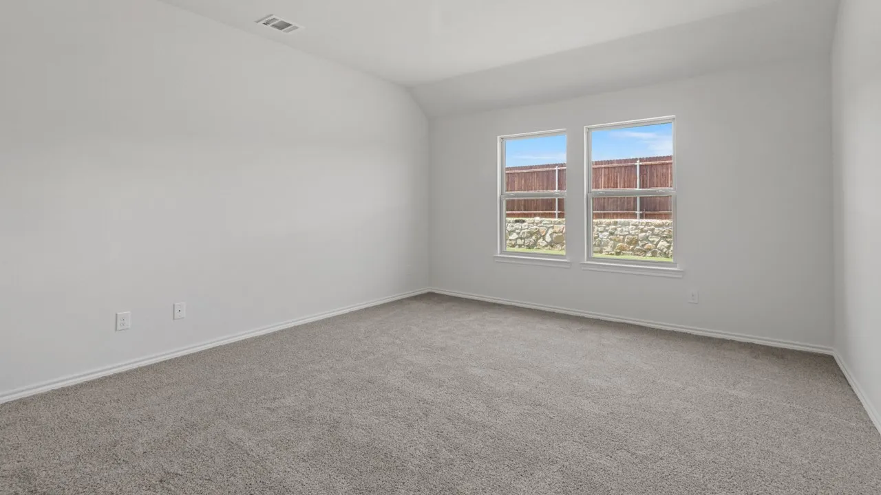 Spacious interior room with light gray carpeting and white painted walls