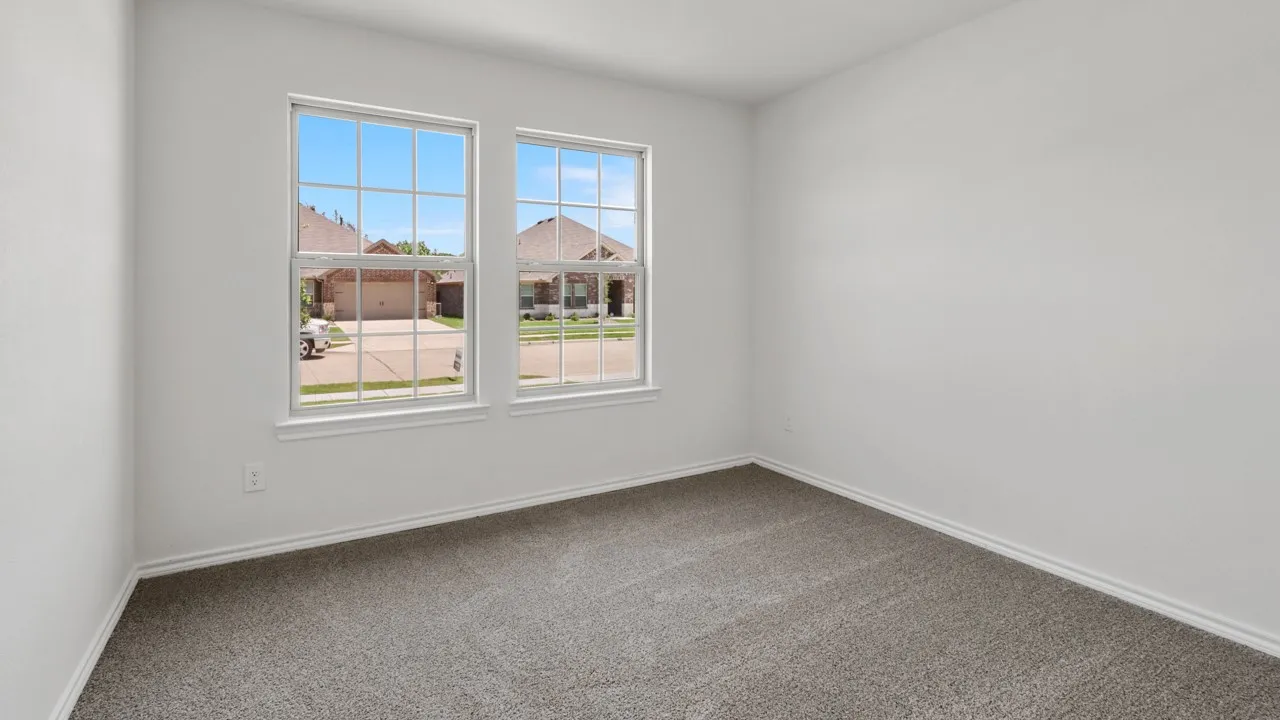 Room featuring dual windows with grids, neutral wall paint, and gray carpet flooring