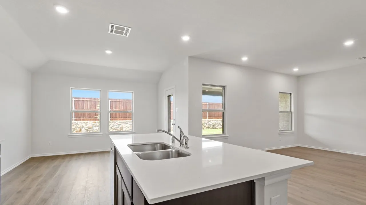 Kitchen island with a double basin sink, chrome faucet, and a light-toned countertop