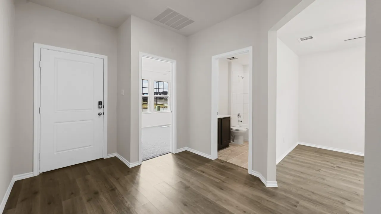 Entryway featuring wood-finish flooring, crisp white trim, and a panel-style front door with smart lock hardware