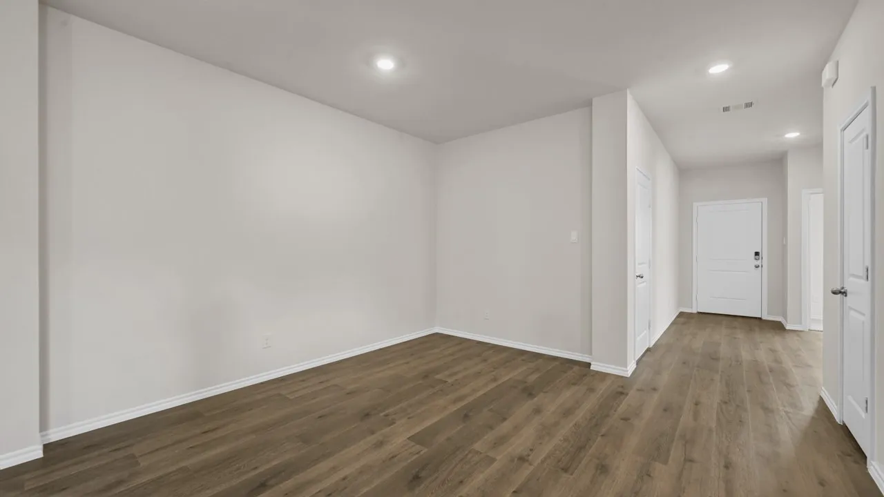 Expansive room featuring wood-finish flooring, recessed lighting, and crisp white walls
