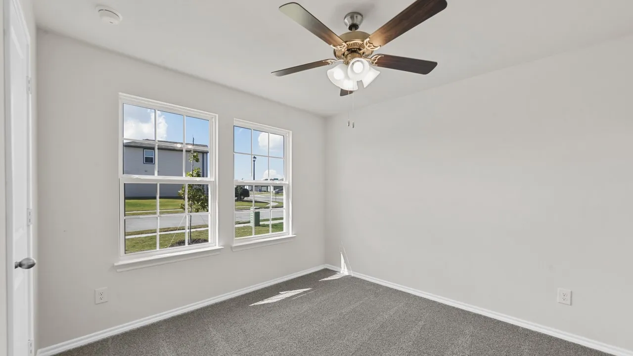 Dual pane windows, ceiling fan with integrated lighting, neutral wall paint, white baseboards, and gray carpeted flooring