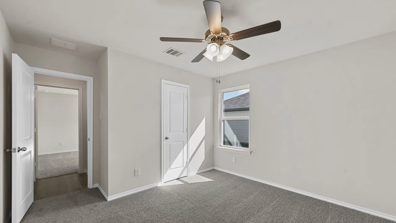 Carpeted room featuring light gray walls, white trim, and a ceiling fan with integrated lighting