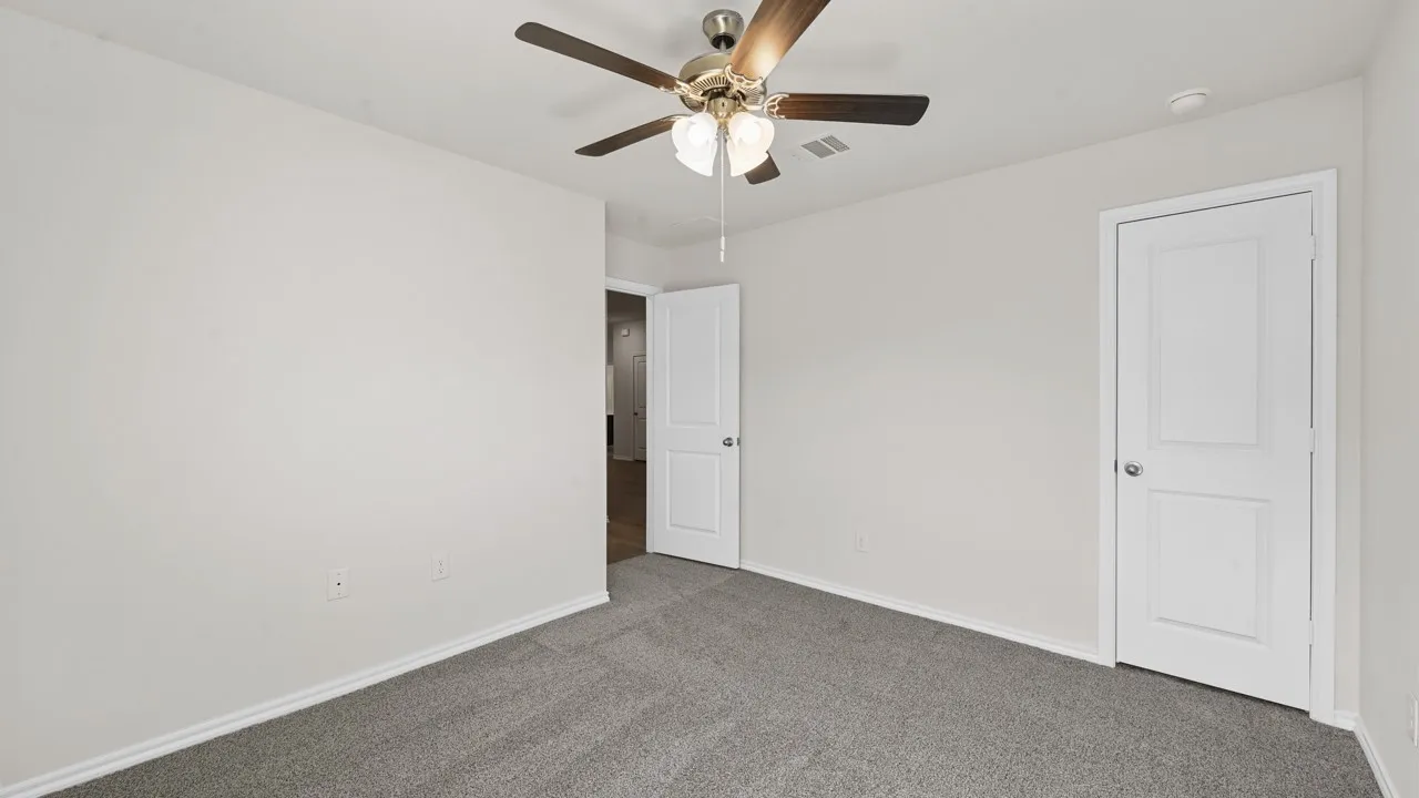 Neutral-toned room featuring gray carpeting, white walls, and white baseboards