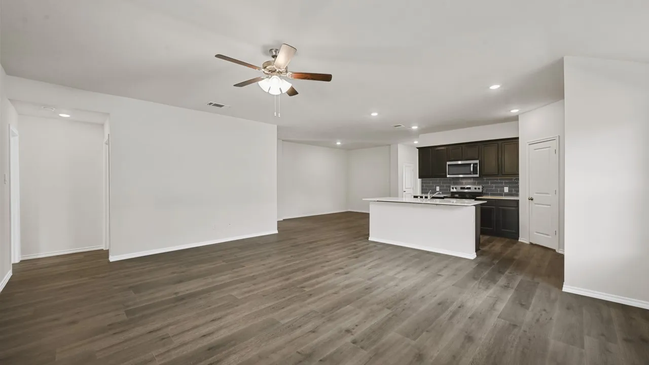 Open-concept living area featuring wood-finish flooring, recessed lighting, and a ceiling fan