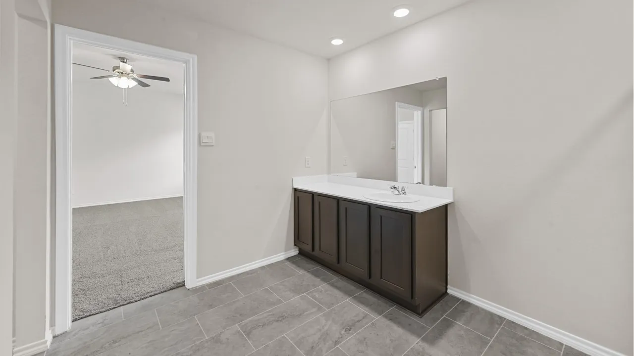 Integrated vanity with a white countertop and rectangular sink, featuring dark wood-finish cabinetry
