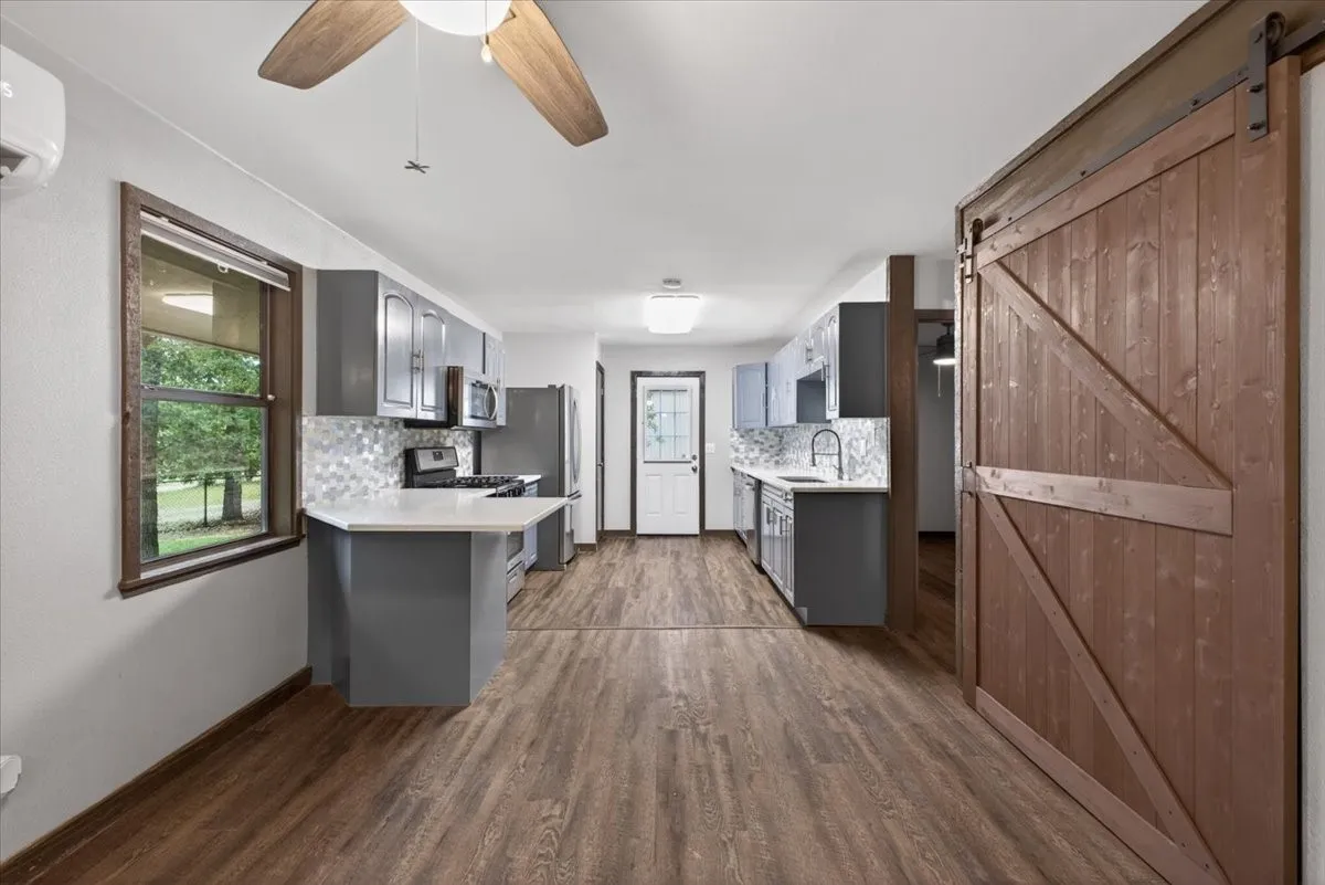 Behind barn doors is the stackable washer/dryer area