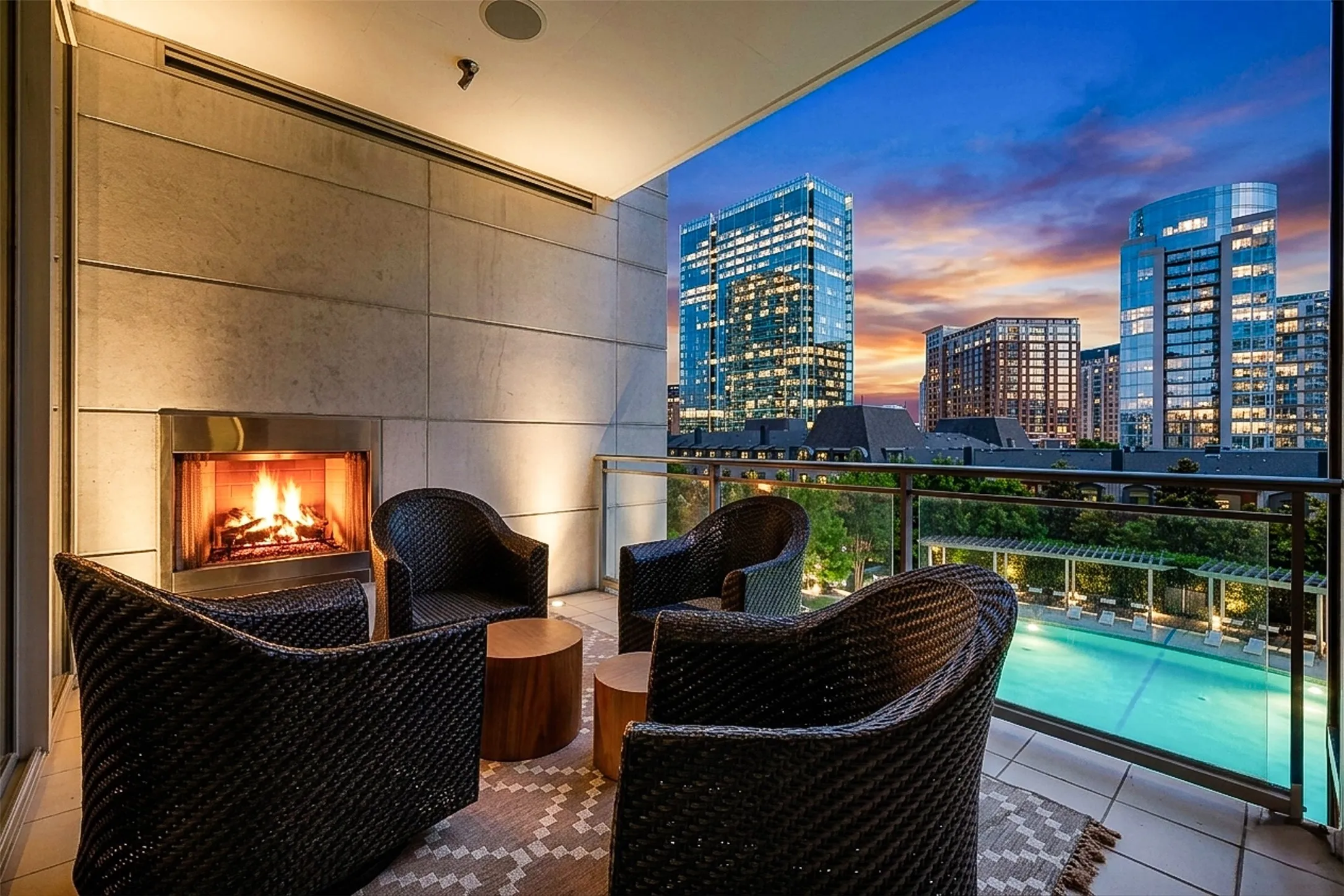 Terrace with fireplace off of the primary bedroom with pool views