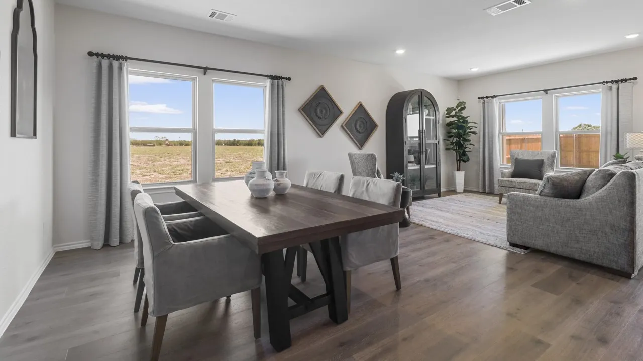 Open-concept living area featuring wood-finish flooring, recessed lighting, and multiple windows
