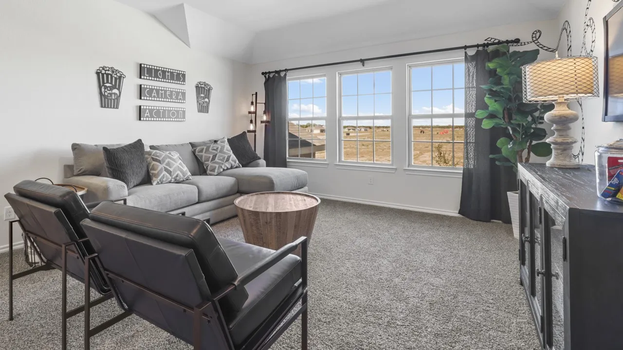 Spacious room featuring three large windows, gray carpet, and white walls