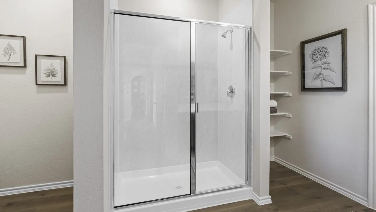 Enclosed shower featuring a clear glass sliding door, chrome fixtures, and a white shower pan