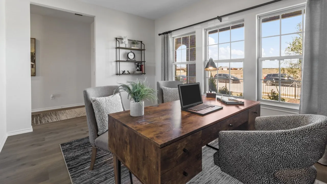 Spacious room featuring multiple large windows, wood-finish flooring, and a wide entryway