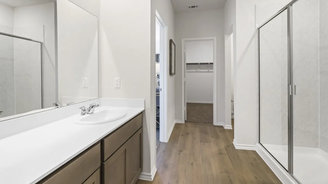 Bathroom vanity with an undermount sink, chrome faucet, and expansive wall mirror