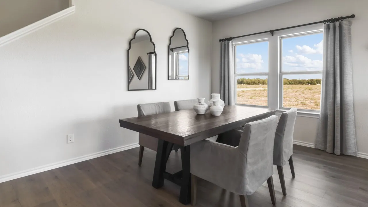 Spacious room featuring wood-finish flooring, white baseboards, and bright white walls