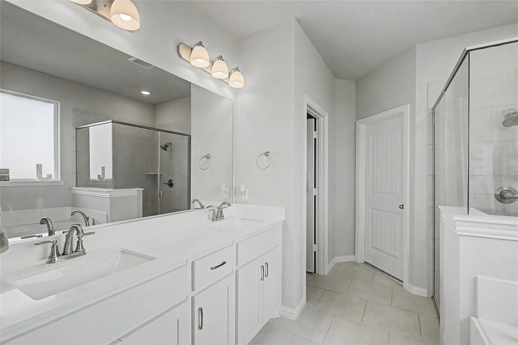 Dual vanity with integrated sinks, brushed nickel fixtures, and ample counter space