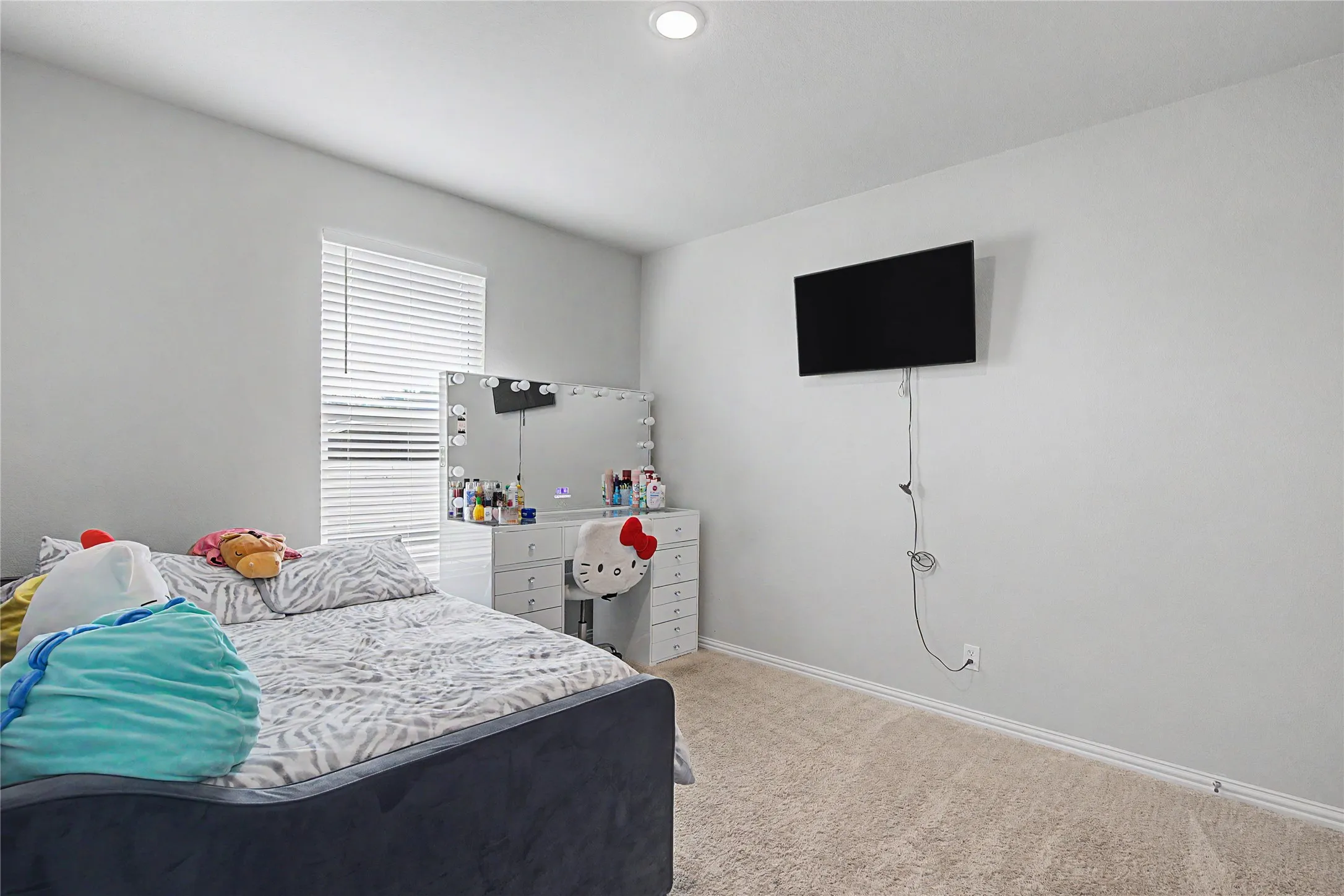 Carpeted room featuring a single window with horizontal blinds, neutral wall paint, and white baseboards