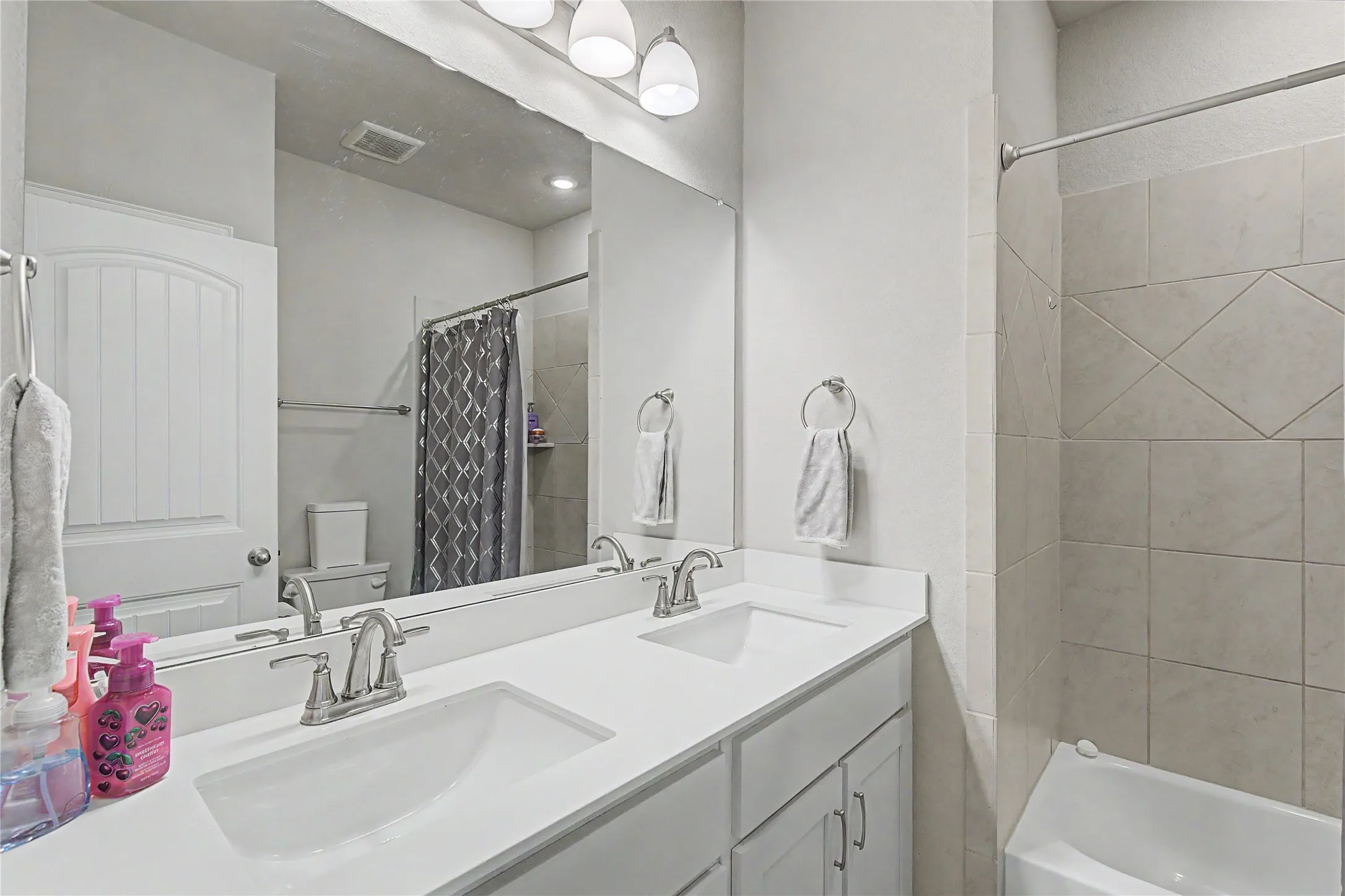 Bathroom featuring a double vanity with white countertops, undermount sinks, and brushed nickel faucets