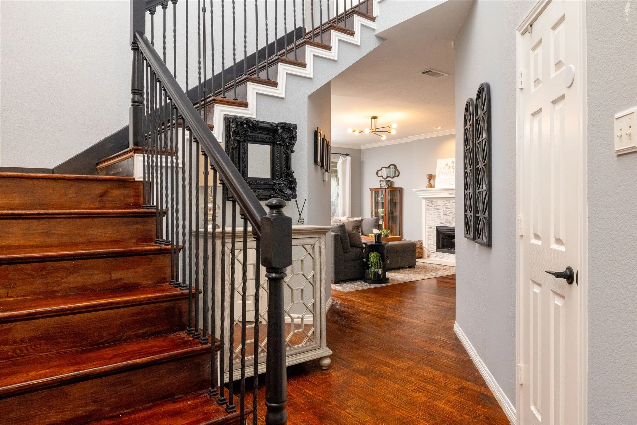 Hardwood staircase with wrought iron balusters and dark wood handrail