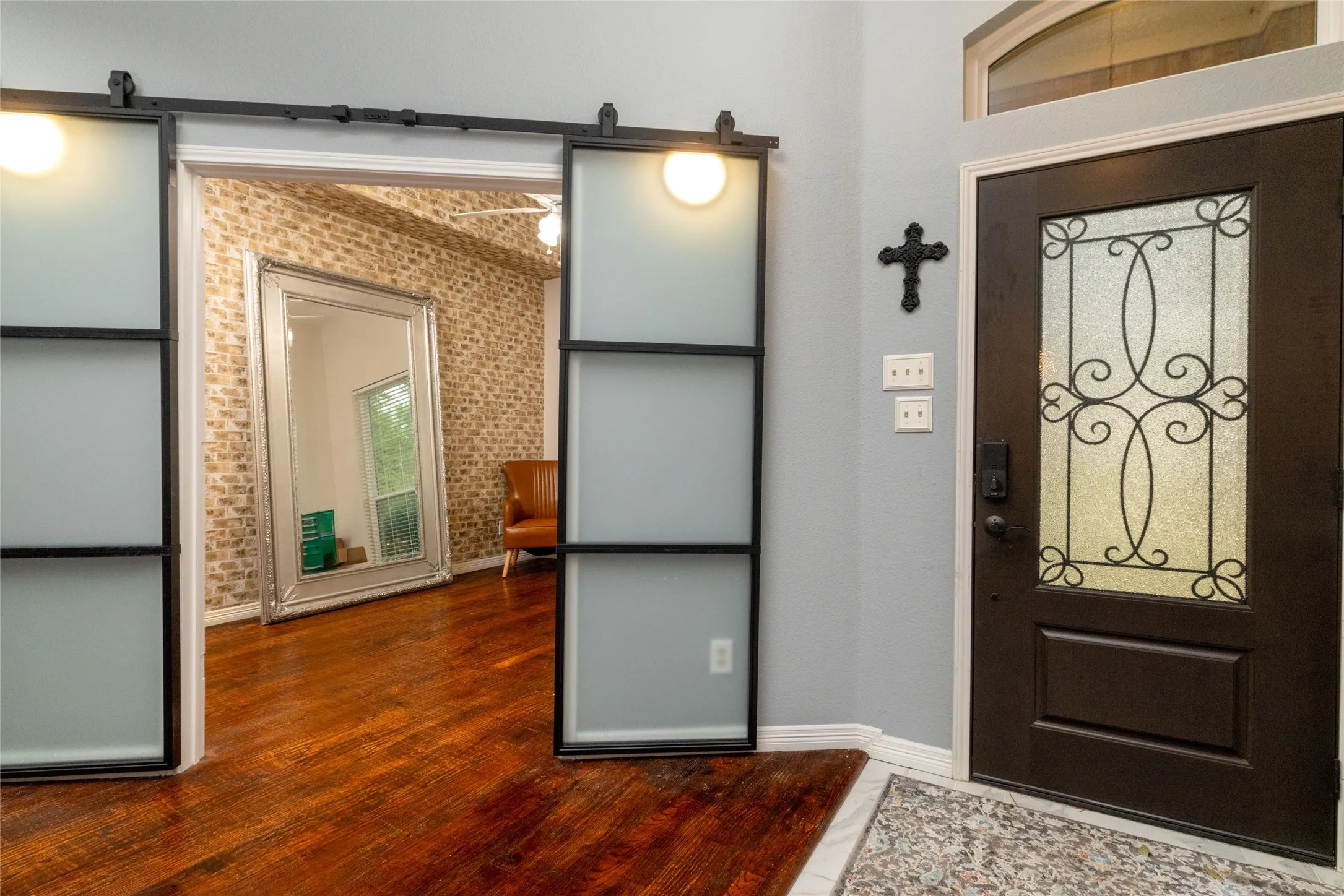 Dark wood-finish entry door with decorative glass inserts and an arched transom window