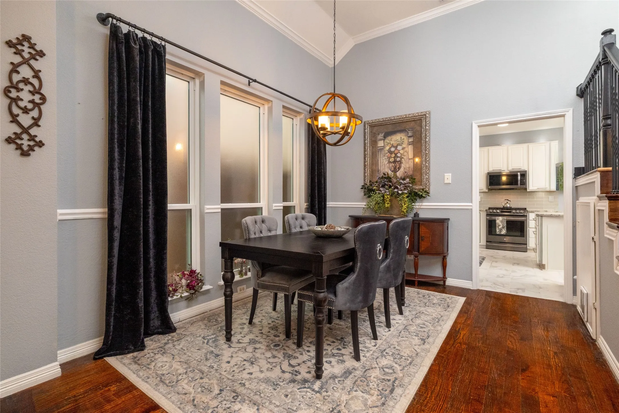 Dining area featuring wood-finish flooring, a vaulted ceiling, and an ornate chandelier