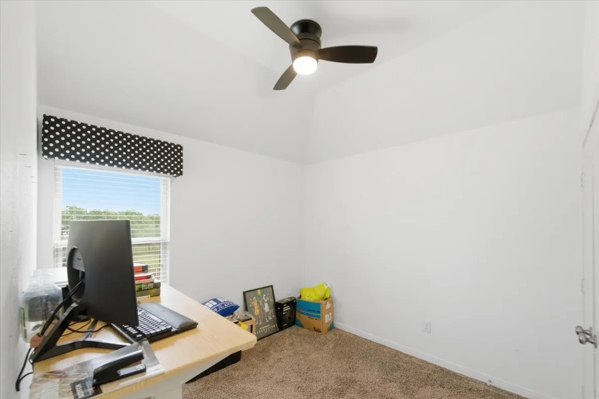 Additional bedroom with vaulted ceiling and ceiling fan