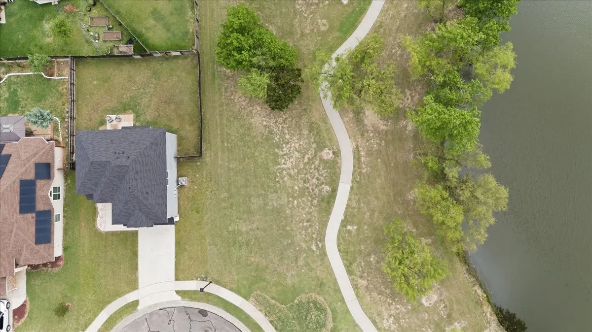 Direct overhead aerial view of home next to pond and walking area