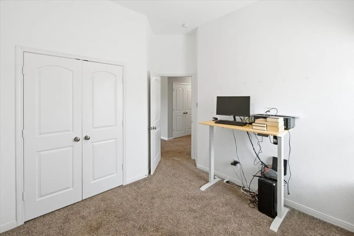 Additional bedroom featuring light colored carpet