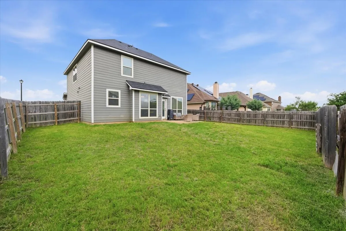 Back of property featuring a fenced backyard and a patio area