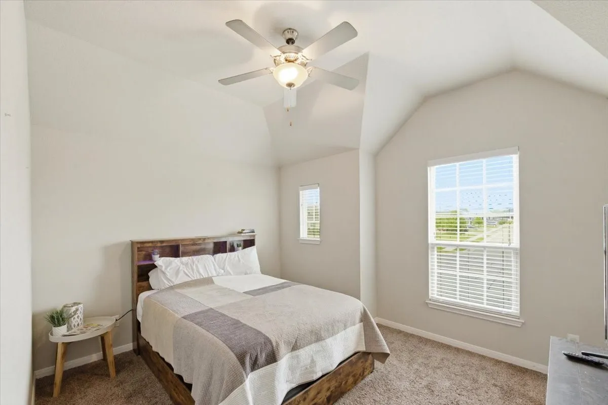 Bedroom featuring light carpet and a ceiling fan